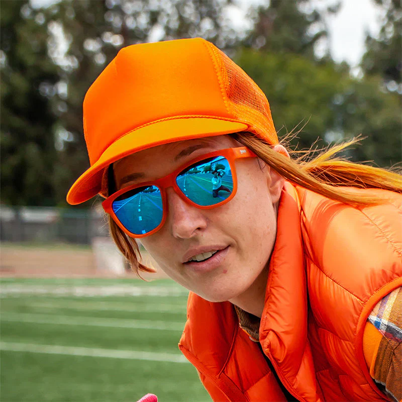 goodr OG Donkey Goggles sunglasses, orange frame with mirrored sky blue lenses — styled product view