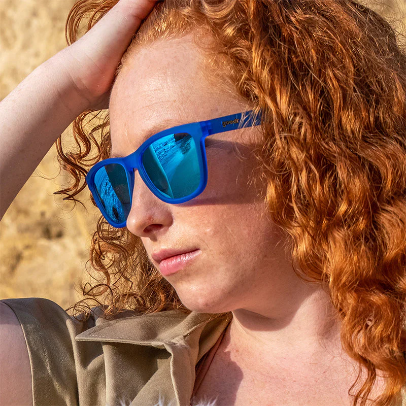 goodr OG Falkor's Fever Dream sunglasses, azure frame with mirrored sky blue lenses — styled product view