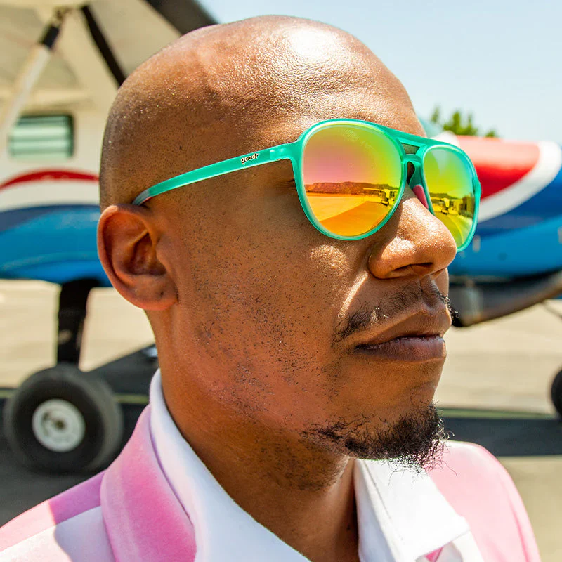 goodr Mach G Kitty Hawkers' Ray Blockers sunglasses, turquoise frame with mirrored hot pink lenses — styled product view