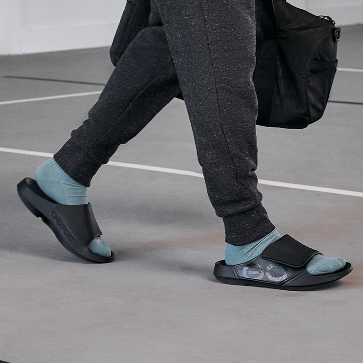 OOFOS OOahh Sport Flex Slide — Matte Black, walking in gym