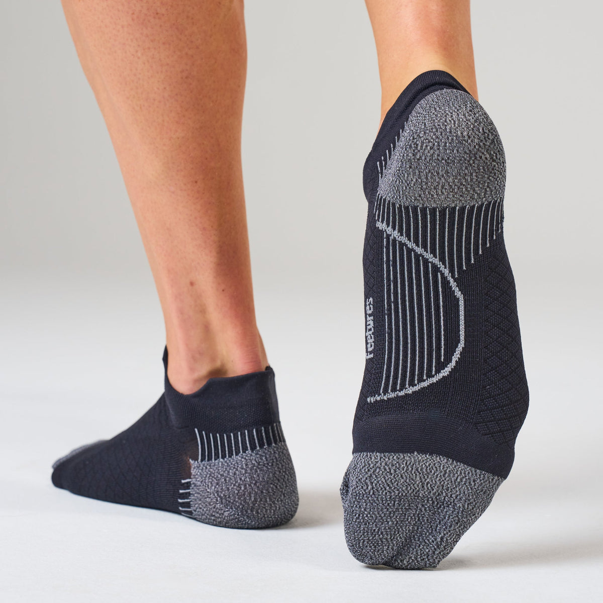 Feetures PF Relief Ultra Light No-Show Tab sock in Black — on foot #Colour_Black