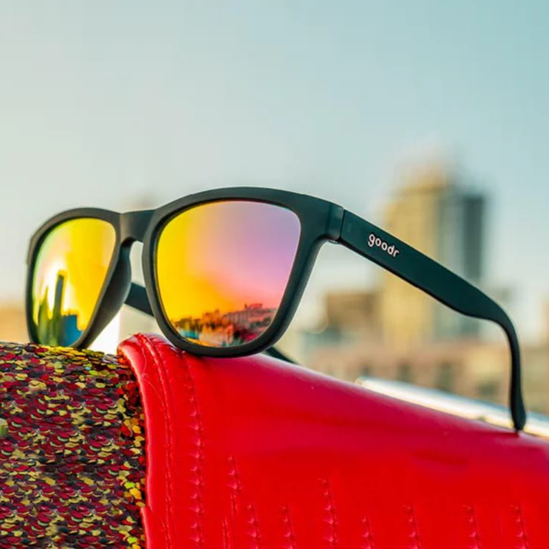 goodr OG Professional Respawner sunglasses, charcoal frame with hot pink lenses — styled product view